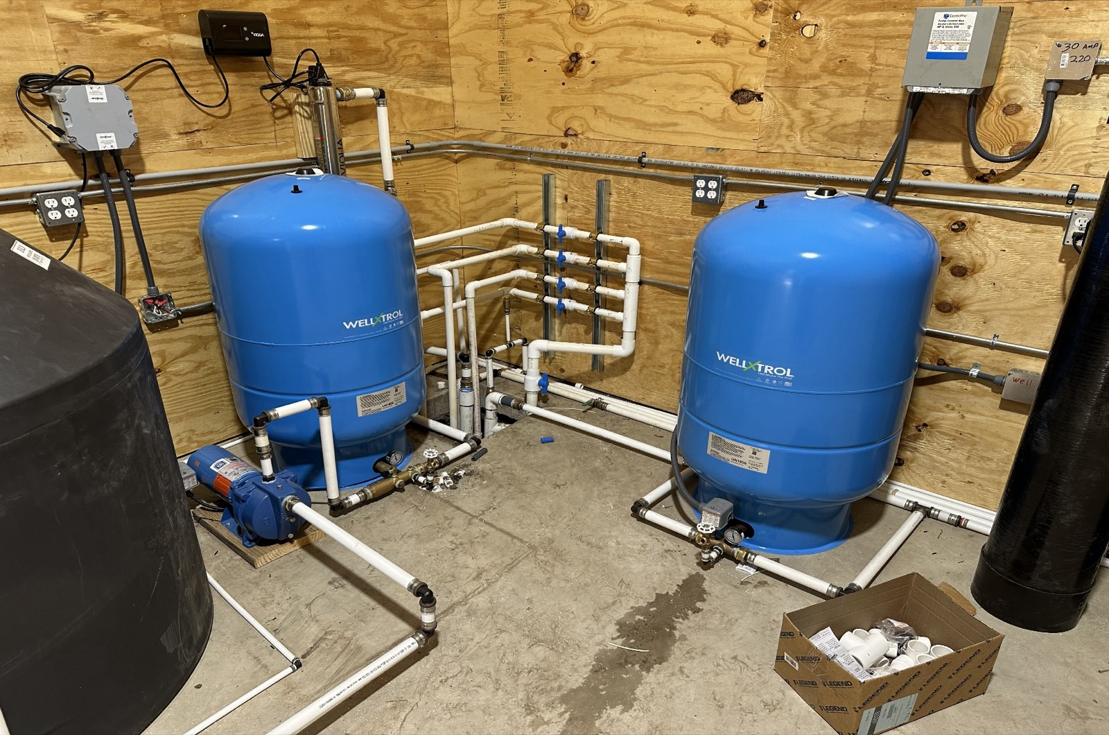 Dual pressure tanks and pump on a well-water pressure system.